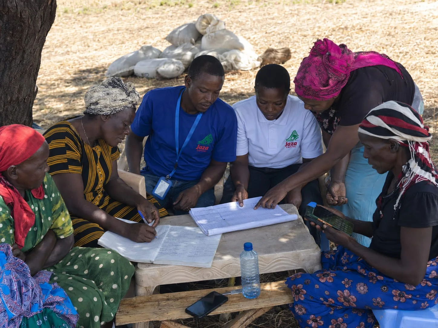 Jaza team and women entrepreneurs reviewing records together
