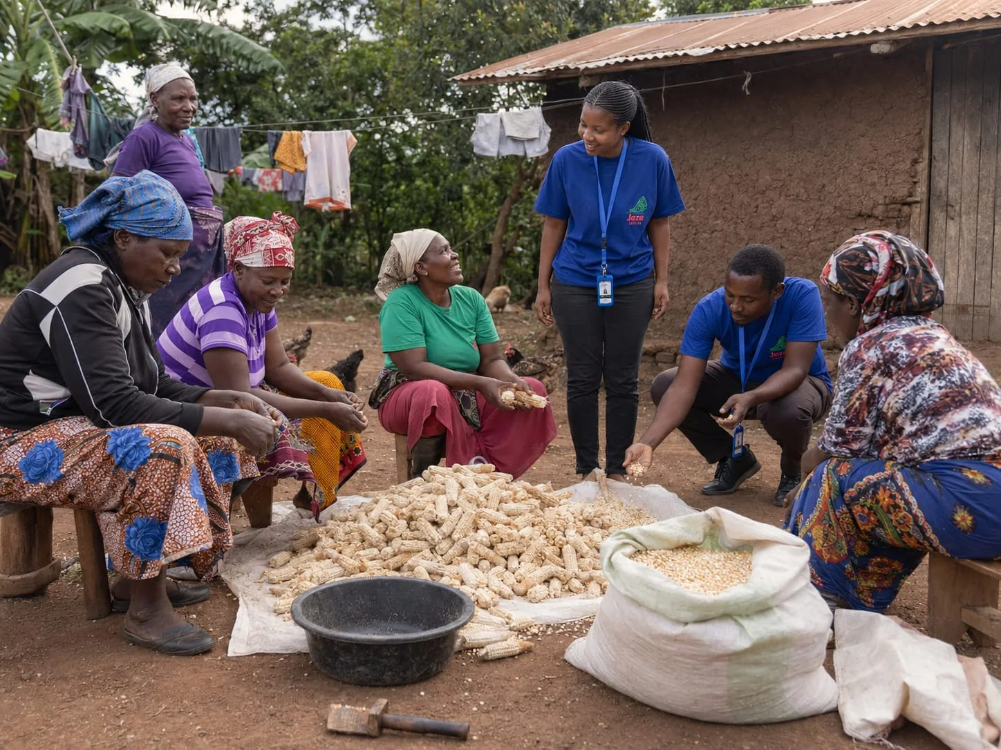 Jaza Capital team speaking with women entrepreneurs processing maize
